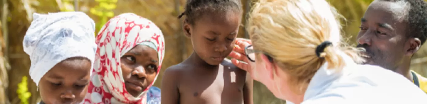 Vrouwelijke arts onderzoekt Afrikaans kind